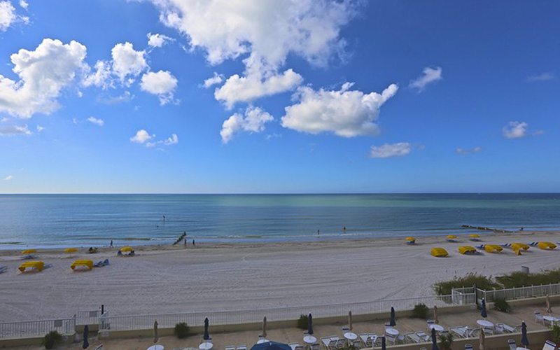 Balcony view, patio in the foreground with the beach and Gulf of Mexico in the background.