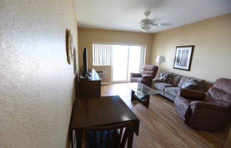 Living Room, two recliners on either side of a sofa which is facing a dresser with a TV on it.