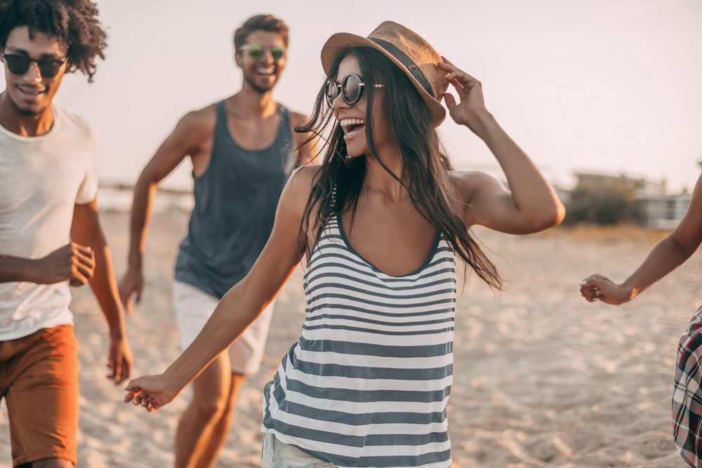 Group of friends hang on the beach at the adult-only hotel, Shoreline Resort