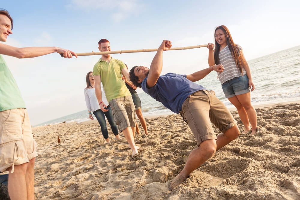 A group friends play limbo, one of the many fun activities to enjoy at Madeira Beach.